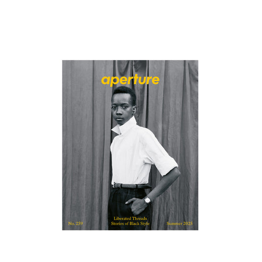 Aperture magazine cover with a person standing against a curtain.